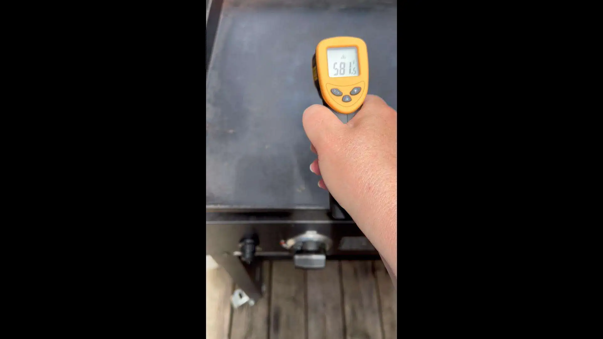 A laser heat thermometer checking the temperature of the griddle.