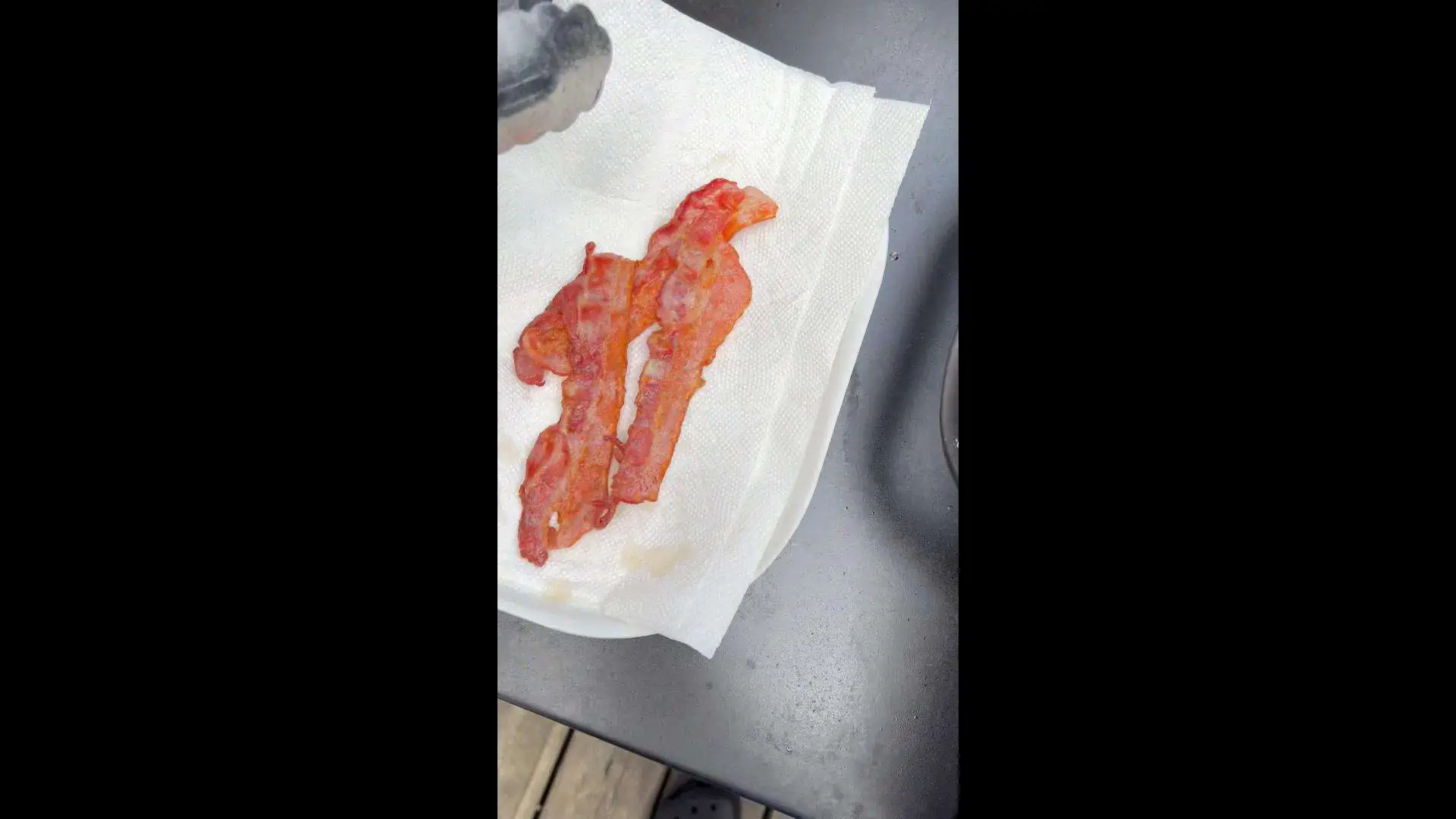 Draining cooked bacon on paper towels.