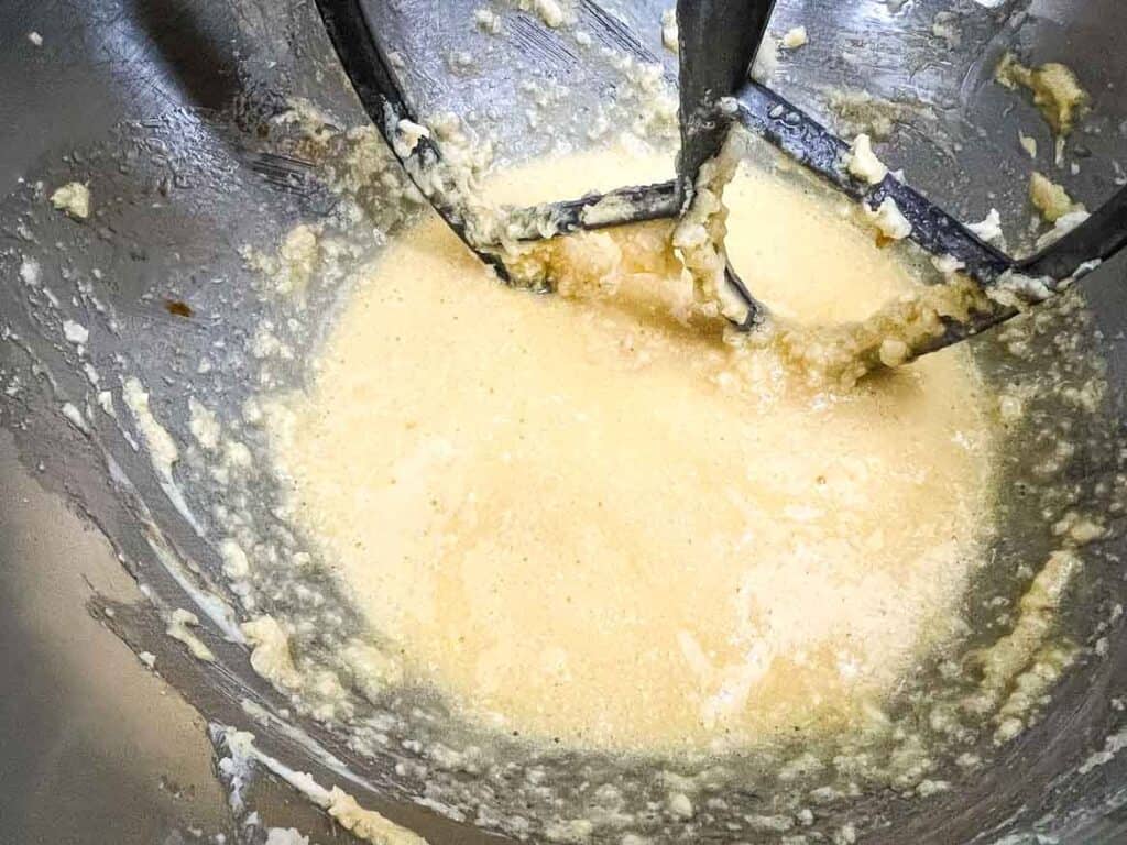 Eggs and dairy mixed in a stand mixer bowl.