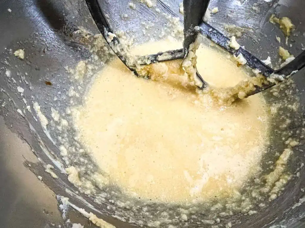 Eggs and dairy mixed in a stand mixer bowl.