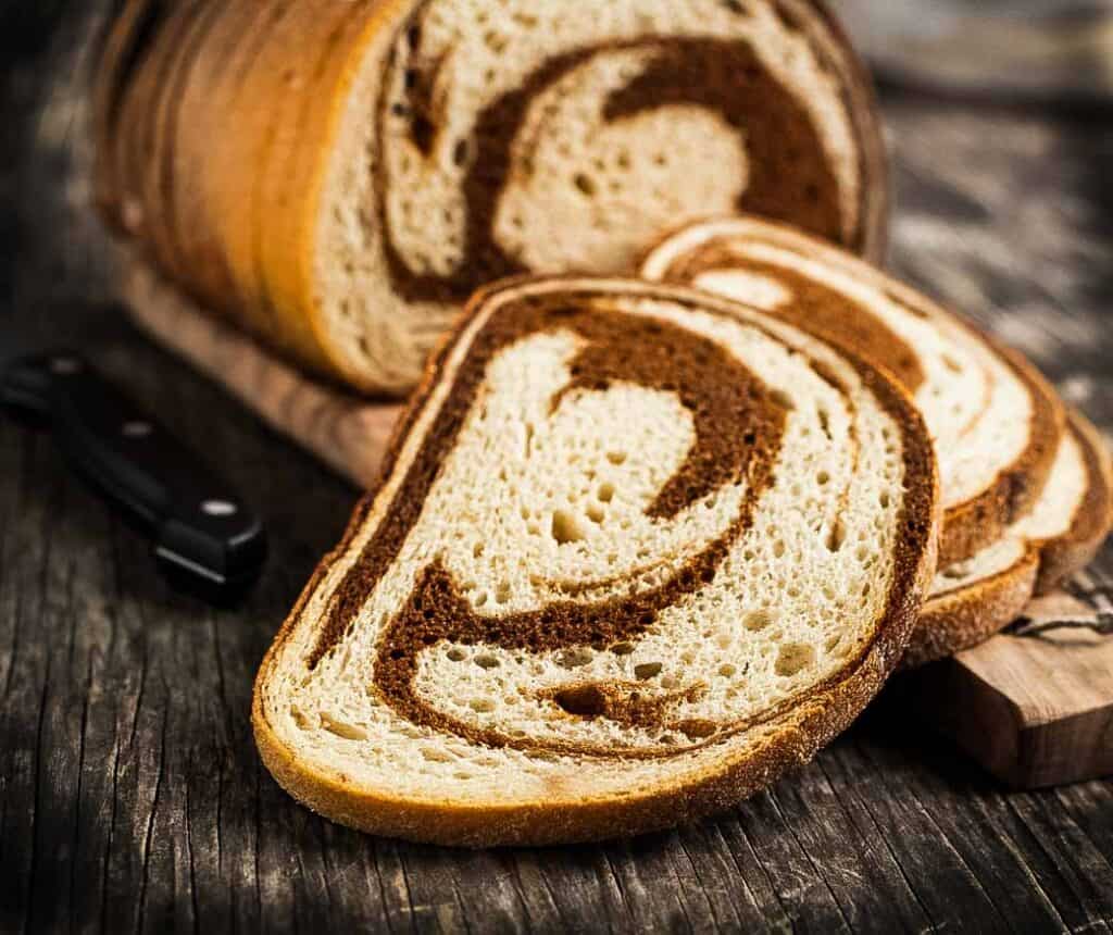Sliced marble rye bread on a cutting board.