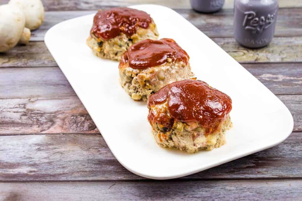 Mini meatloaves on a white platter.