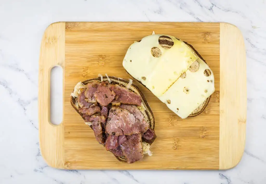 Sliced cheese on one half, meat on the other half of the sandwich.