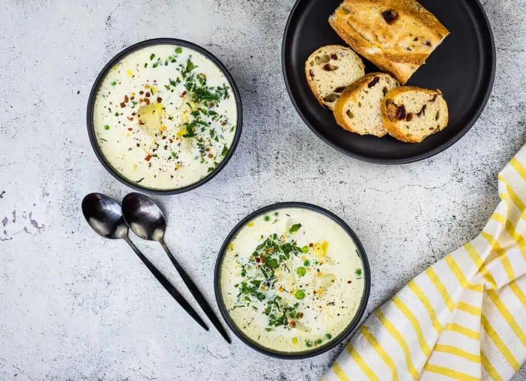 Finished Potato & Pea Chowder in two black bowls.