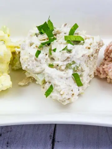 A trio of salads on a plate.
