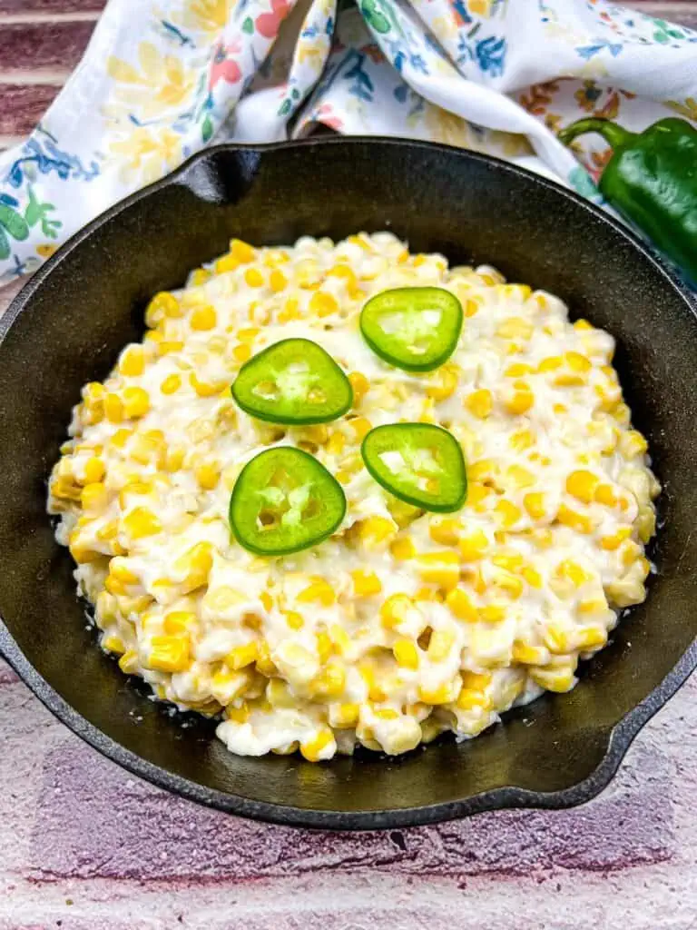 Smoked creamed corn in a black skillet.