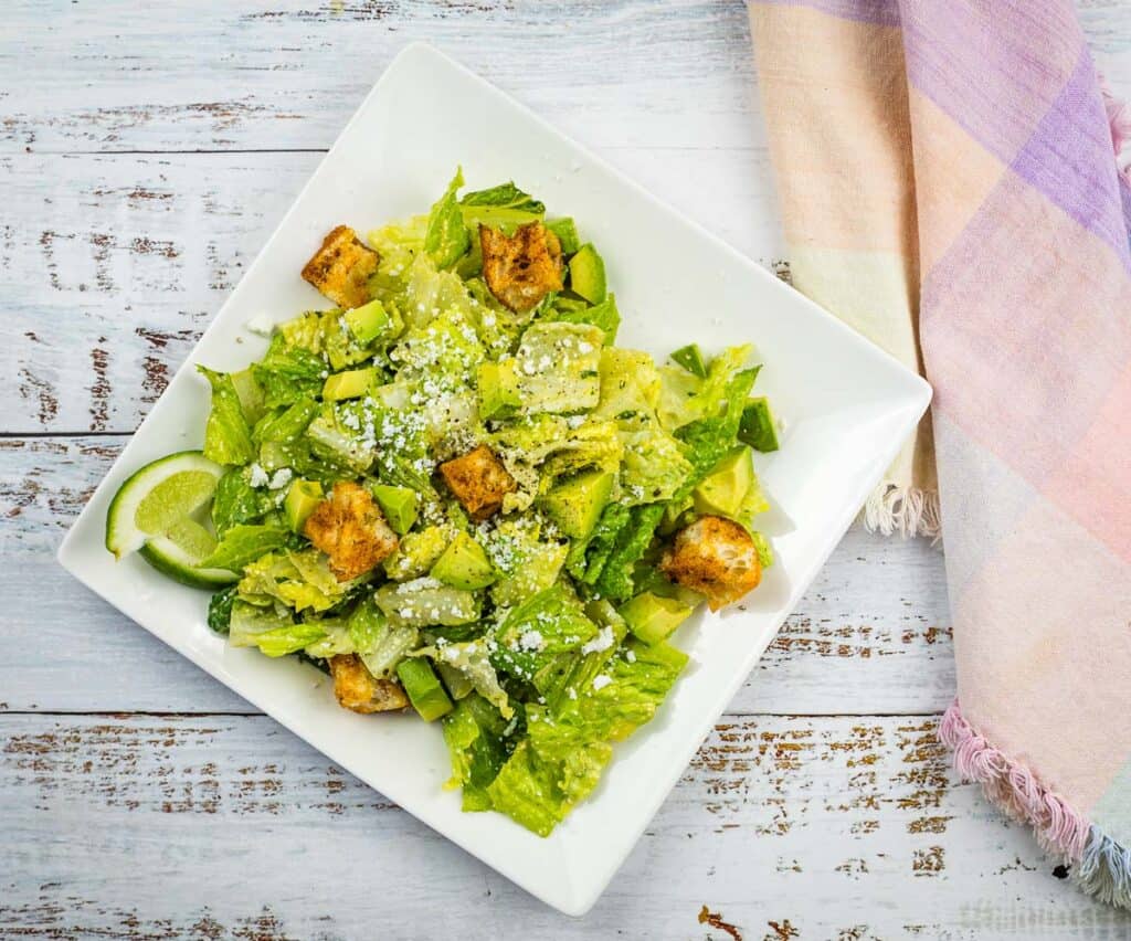 A top-down shot of a Tex-Mex Caesar Salad on a white plate.