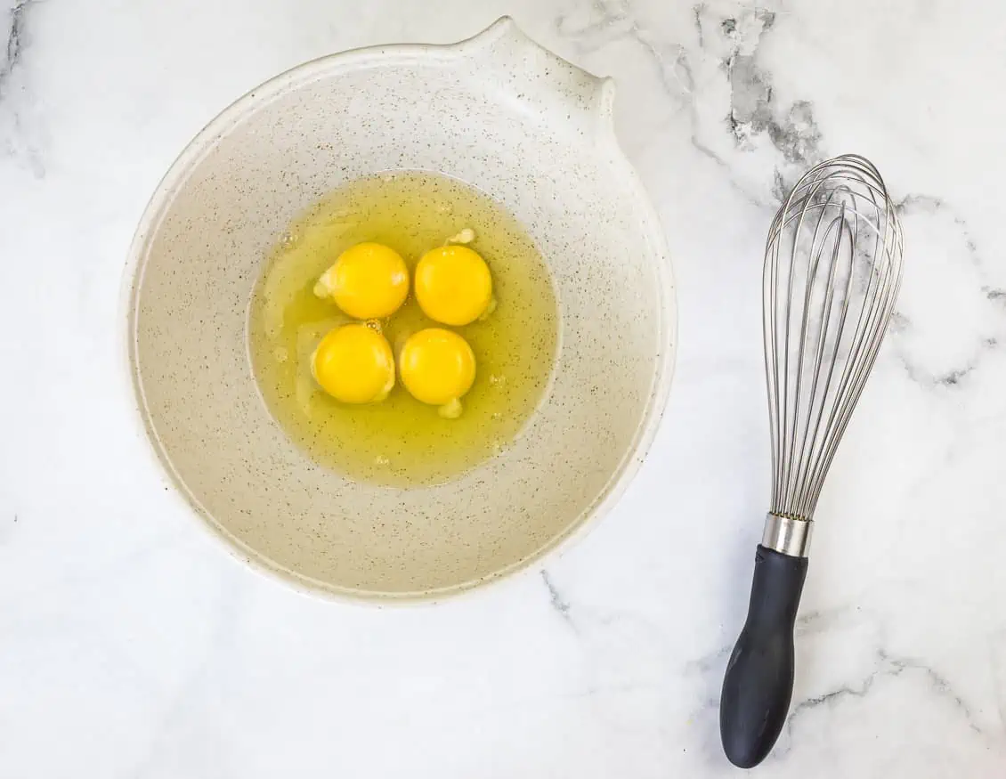 Eggs in a bowl with a whisk.