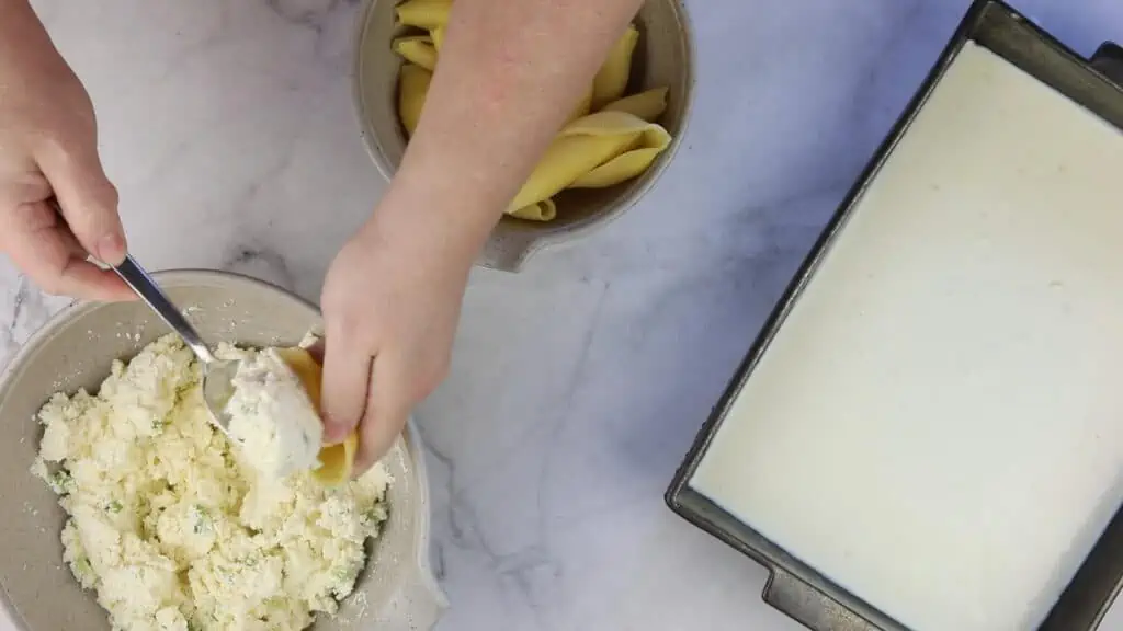 Filling the pasta shells.