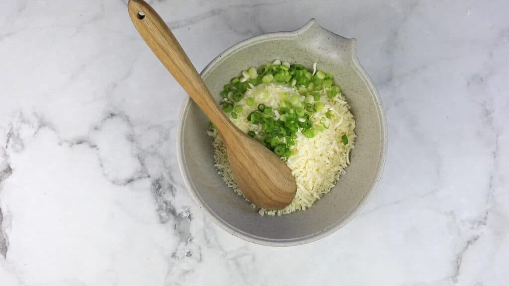 Mixing the cheese, green onions and seasoning.