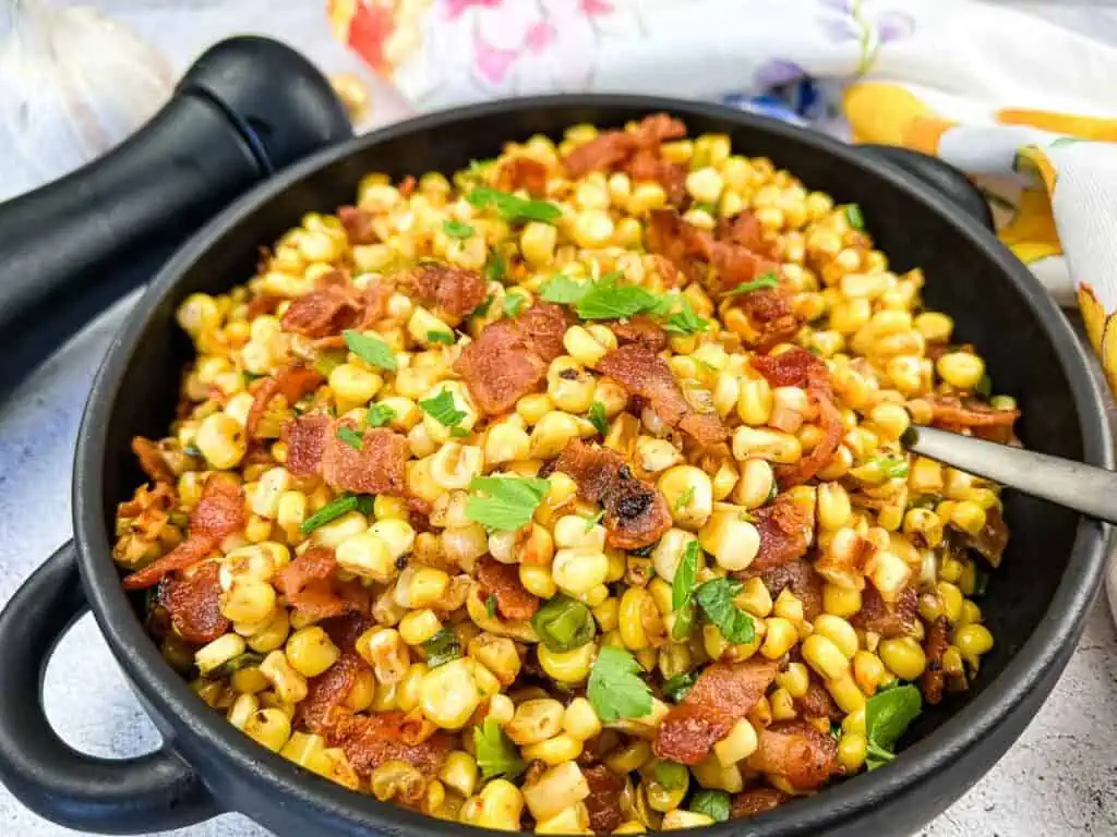 Finished Bacon-Fried Corn in a black serving bowl.