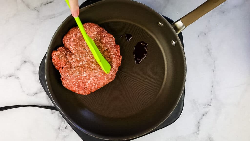 Browning the ground beef in a skillet.