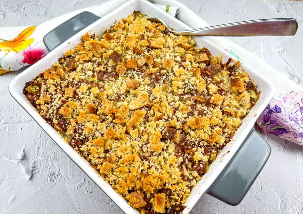 Canned corned beef hash in a baking dish with a spoon.