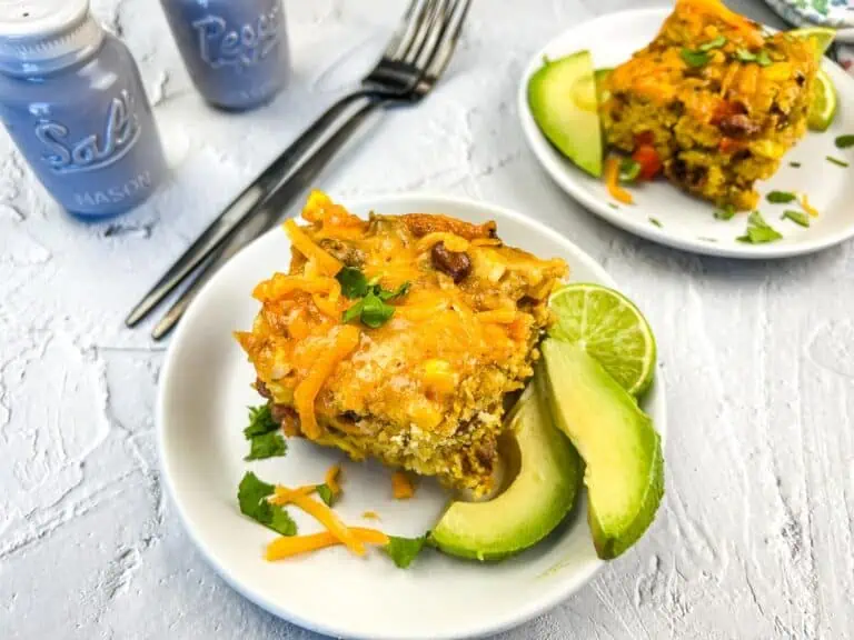 A closeup of 2 slices of cowboy cornbread casserole on plates.