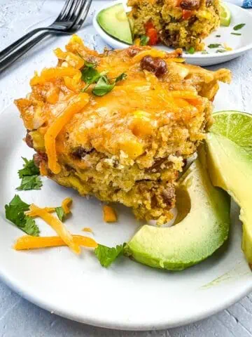 Cowboy Cornbread Casserole on a plate with avocado.