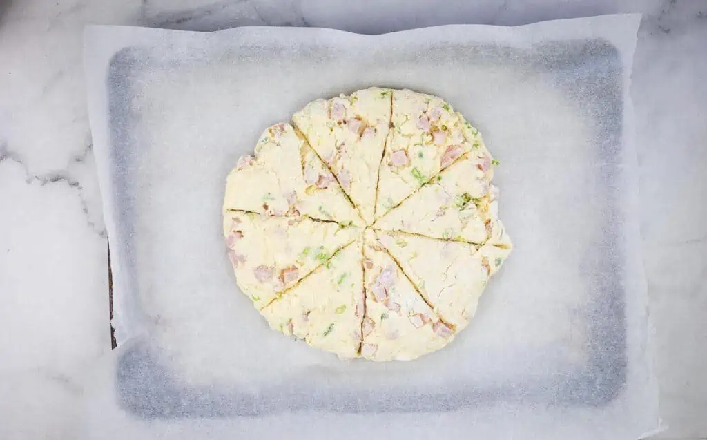 Ham & Cheese Scone dough patted into round shape and cut into wedges.