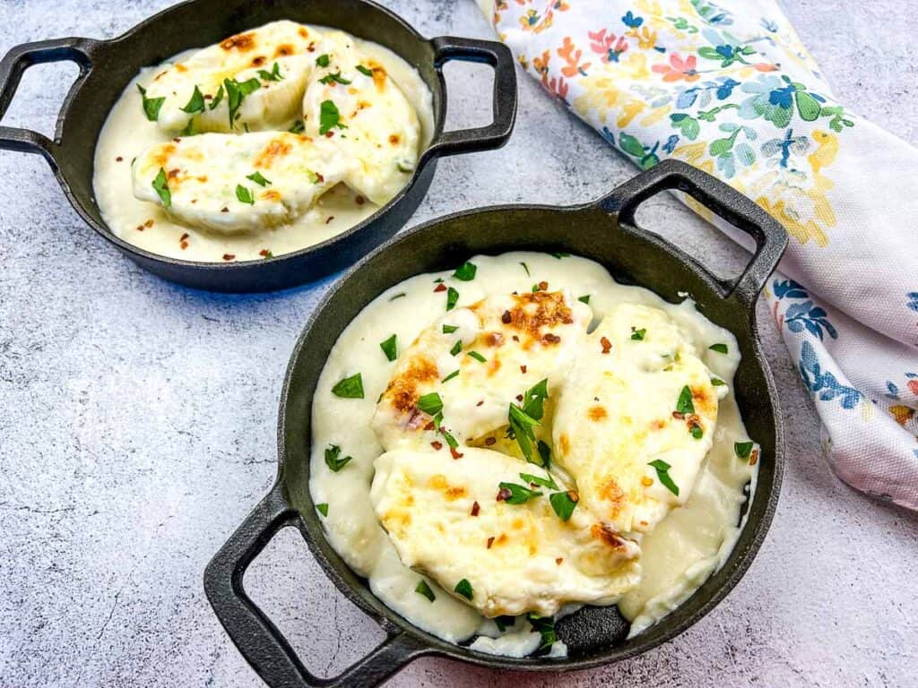 A horizontal shot of 2 individual sized servings of Cheese Stuffed Pasta Shells.