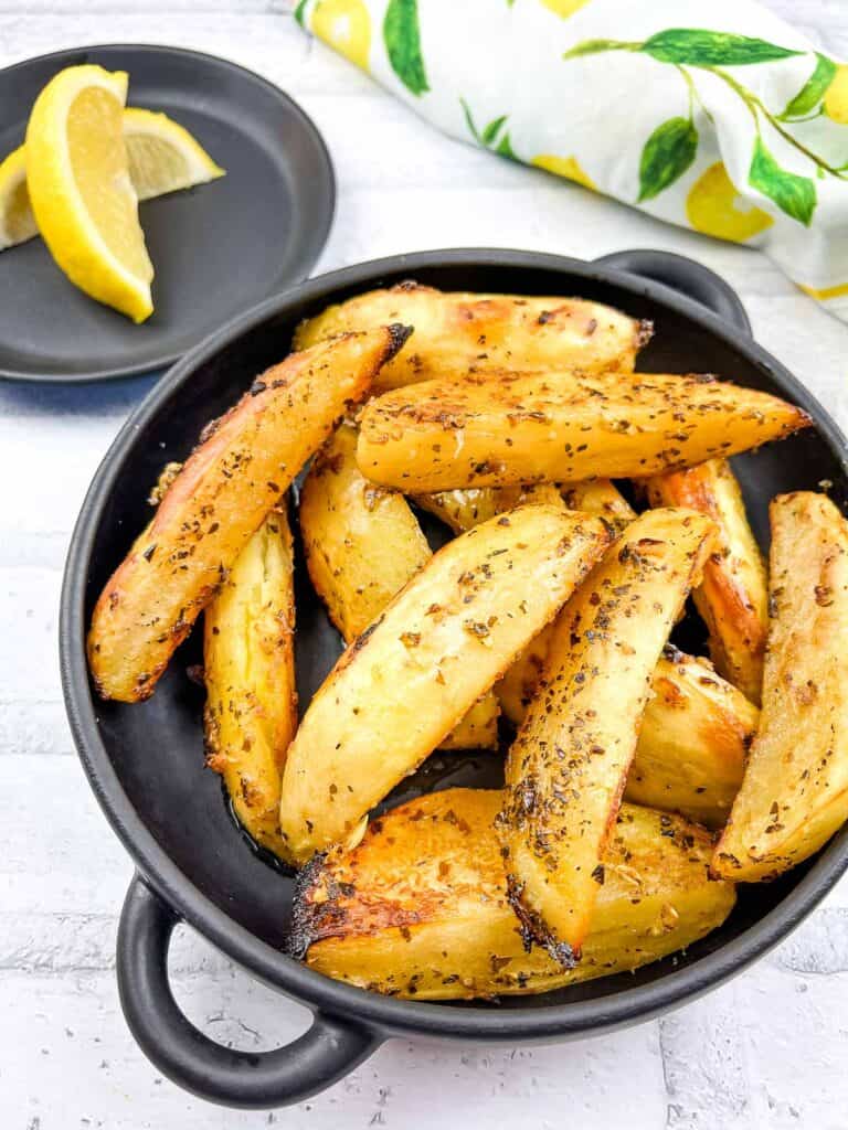 Greek Lemon Potatoes in a black serving bowl.