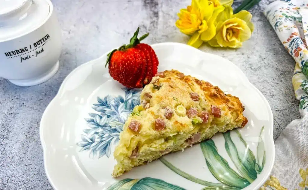 A finished Ham & Cheese Scone on a plate with a berry.