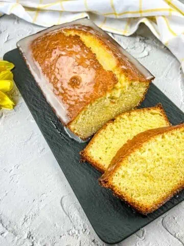 Lemon Loaf with on a black platter with a few slices.