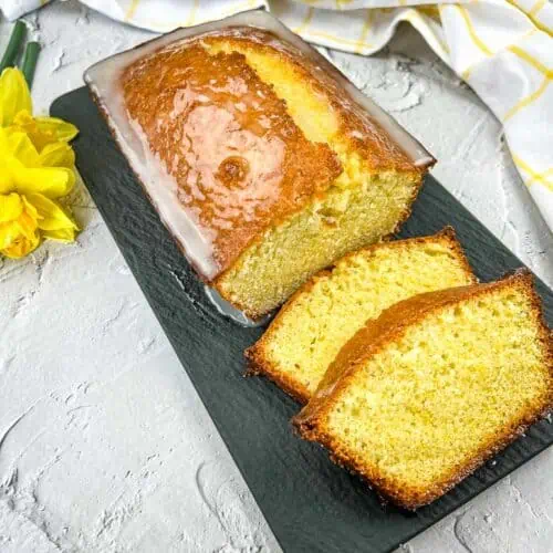 Lemon Loaf with on a black platter with a few slices.