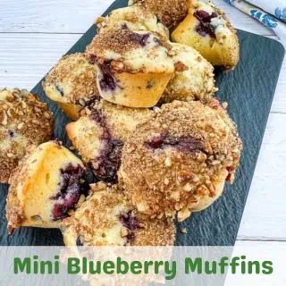 Mini blueberry muffins on a black plate.