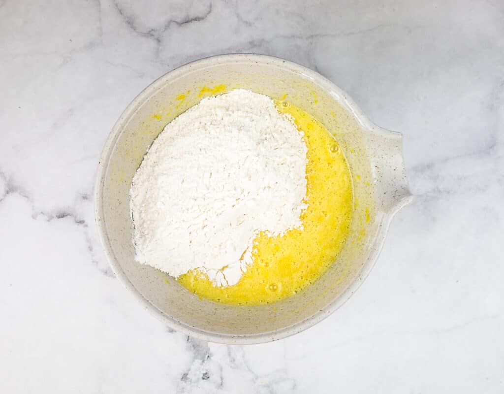 Flour added to the egg and sugar mixture.