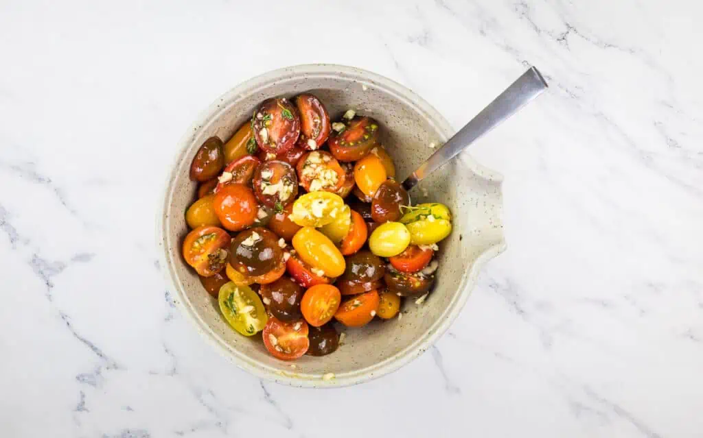 Mixing the tomatoes with garlic and herbs.