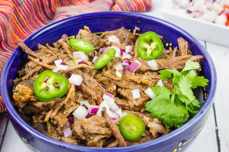 Beef barbacoa in a blue serving dish.