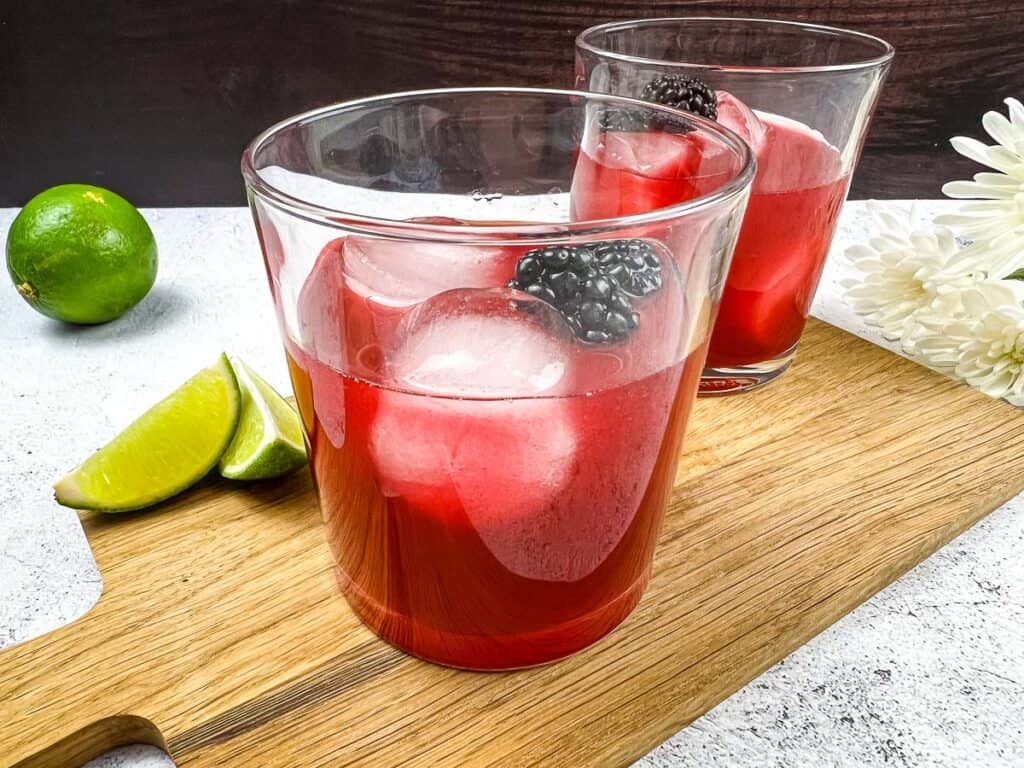 Smoked Blackberry Margarita ingredients added to a glass.