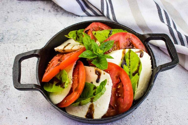 Caprese salad in a black dish.