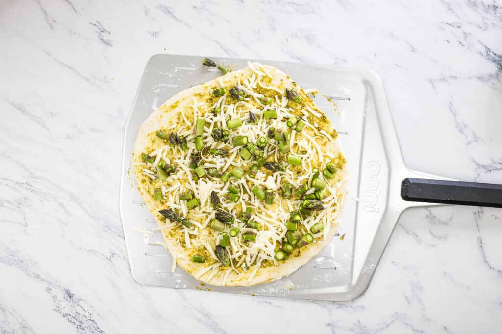 Pizza topped with cheese and asparagus.