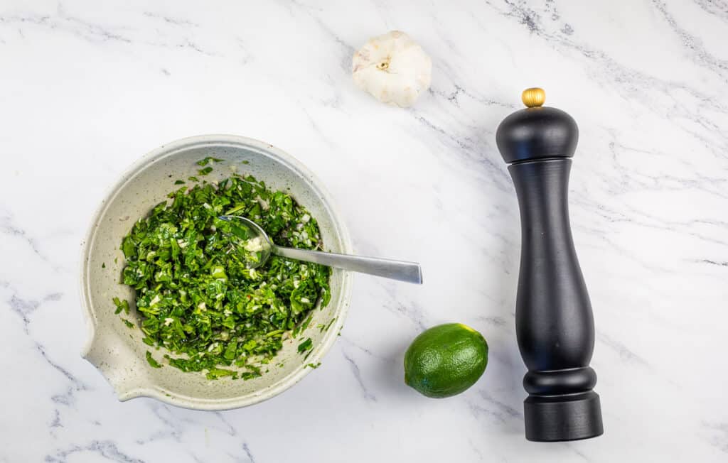 Chopped herbs added to the chimichurri sauce.