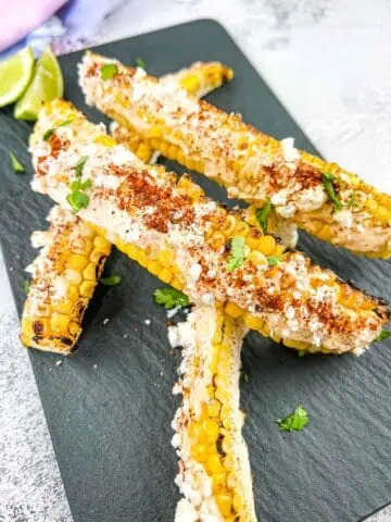 Grilled Elote Corn Ribs on a black plate.