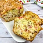 Best Rhubarb Bread on a platter with a few slices in the front.