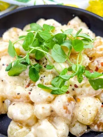 Gnocchi with Lemon Parmesan Sauce in a black serving bowl
