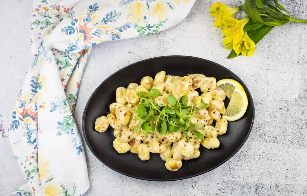 A top-down shot of a plate of gnocchi with lemon sauce.
