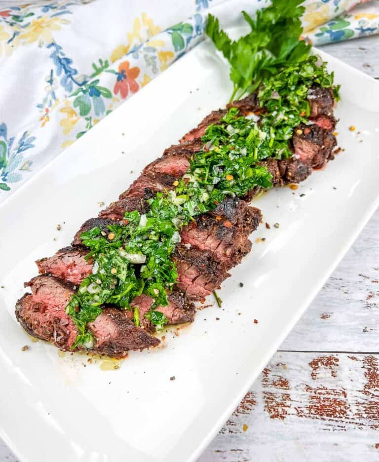 Grilled Hanger Steak with Chimichurri on a white platter.