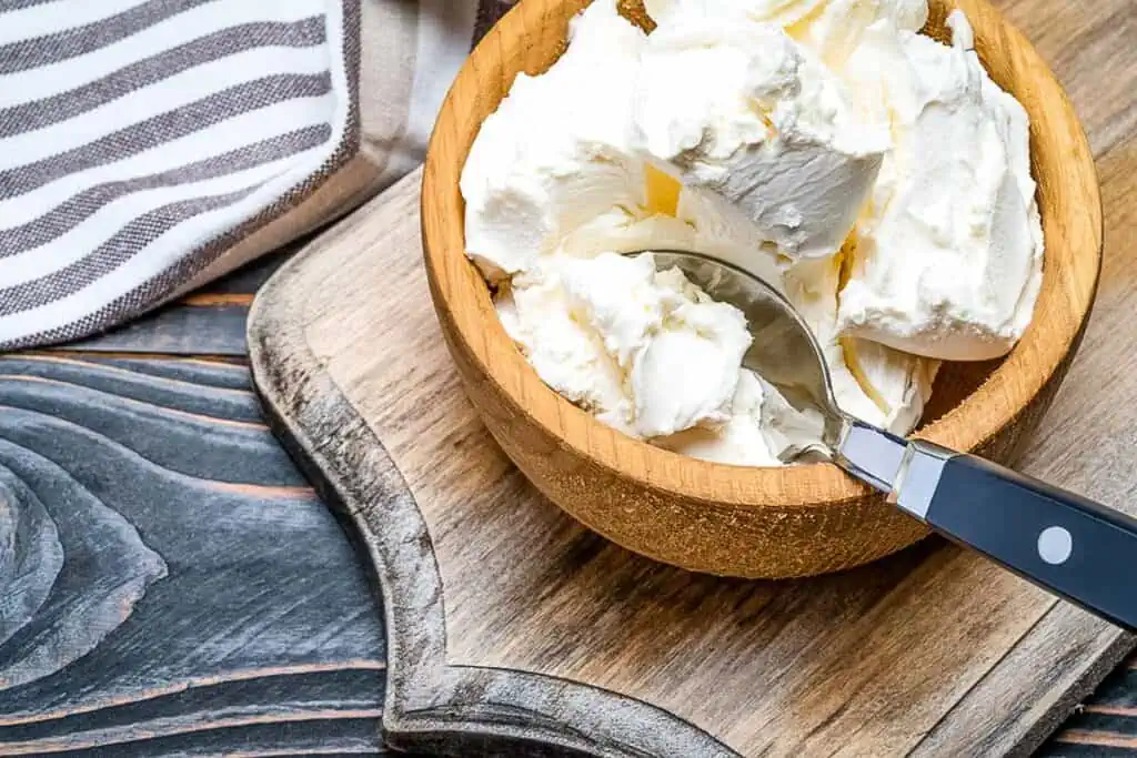 Mascarpone cheese in a bowl with spoon.