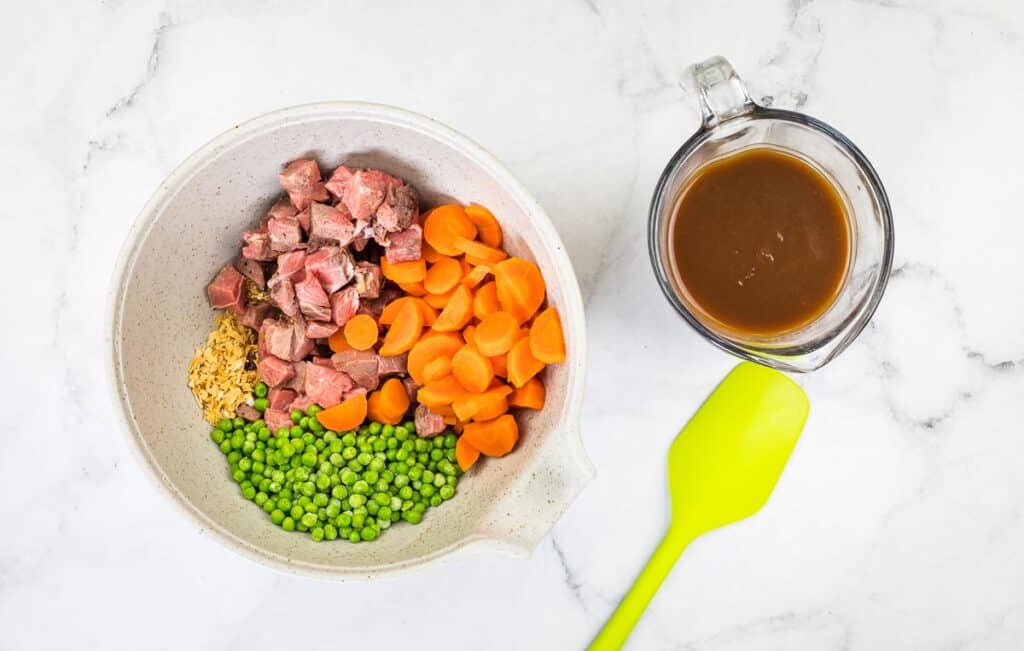 The filling ingredients in a bowl next to gravy.