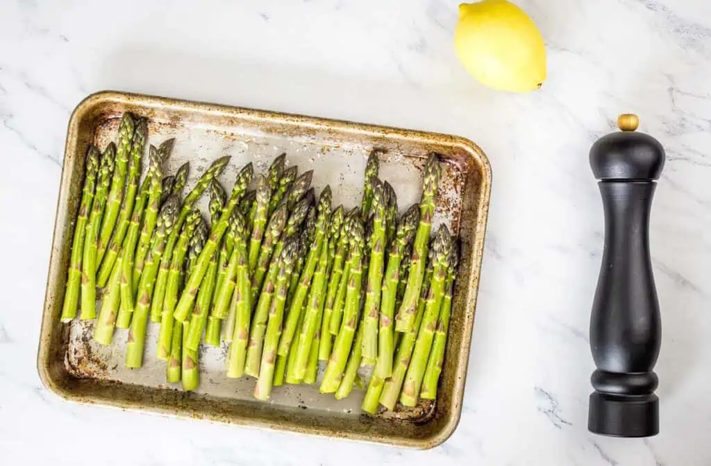 Asparagus on a sheet pan ready for roasting.