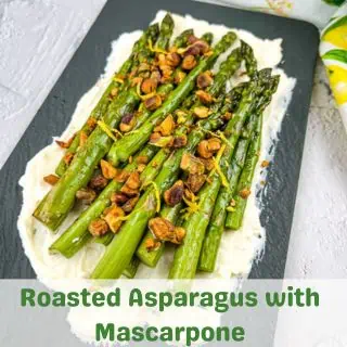 Oven roasted asparagus with mascarpone on a black platter.