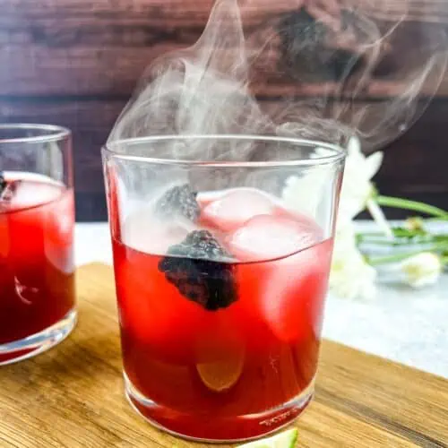 Smoked Blackberry Margarita in a glass with a second cocktail behind.