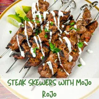 Grilled steak skewers with mojo rojo on a plate.