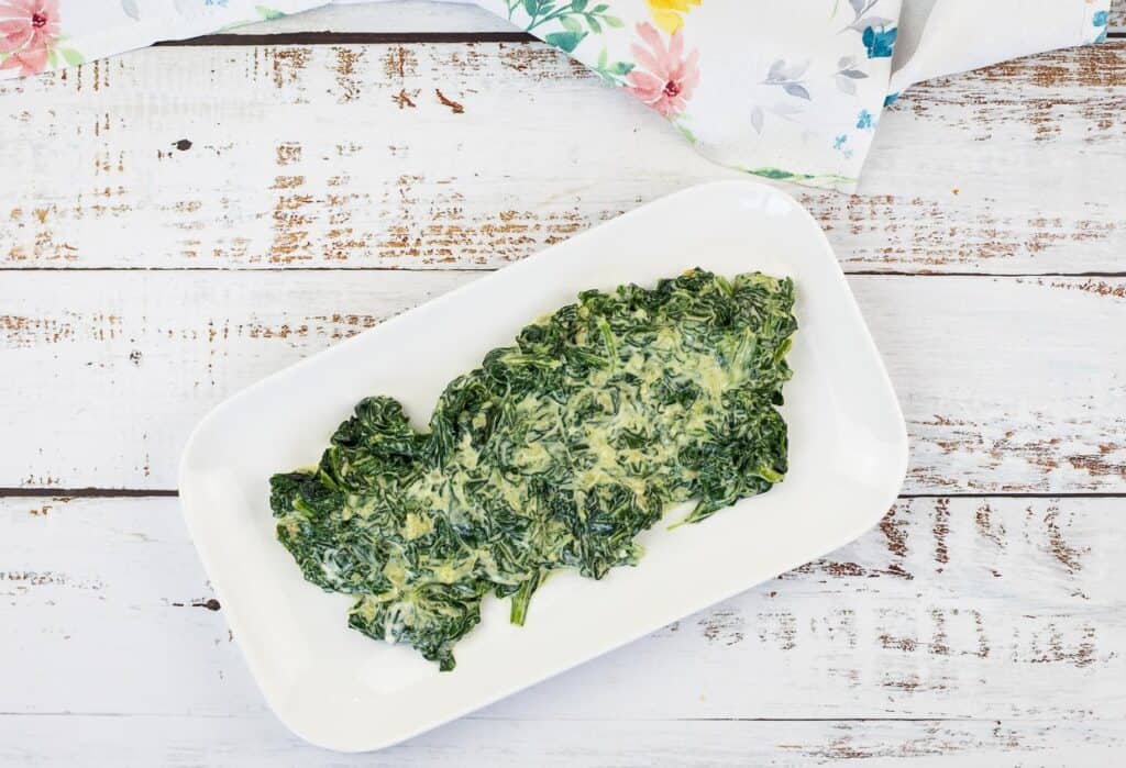 A top-down shot of Creamed Spinach with Mascarpone on a white dish.