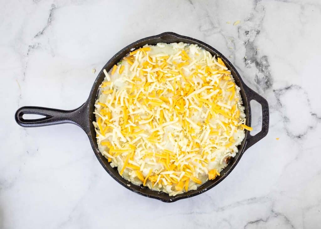 The dish topped with cheddar cheese.
