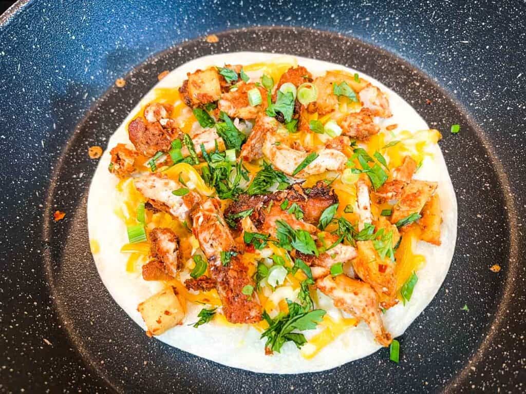 Chicken, green onion, cilantro added to tortilla.