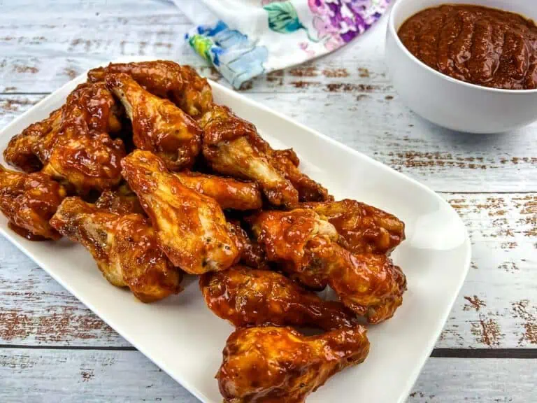 Chicken wings with BBQ sauce on a white plate.