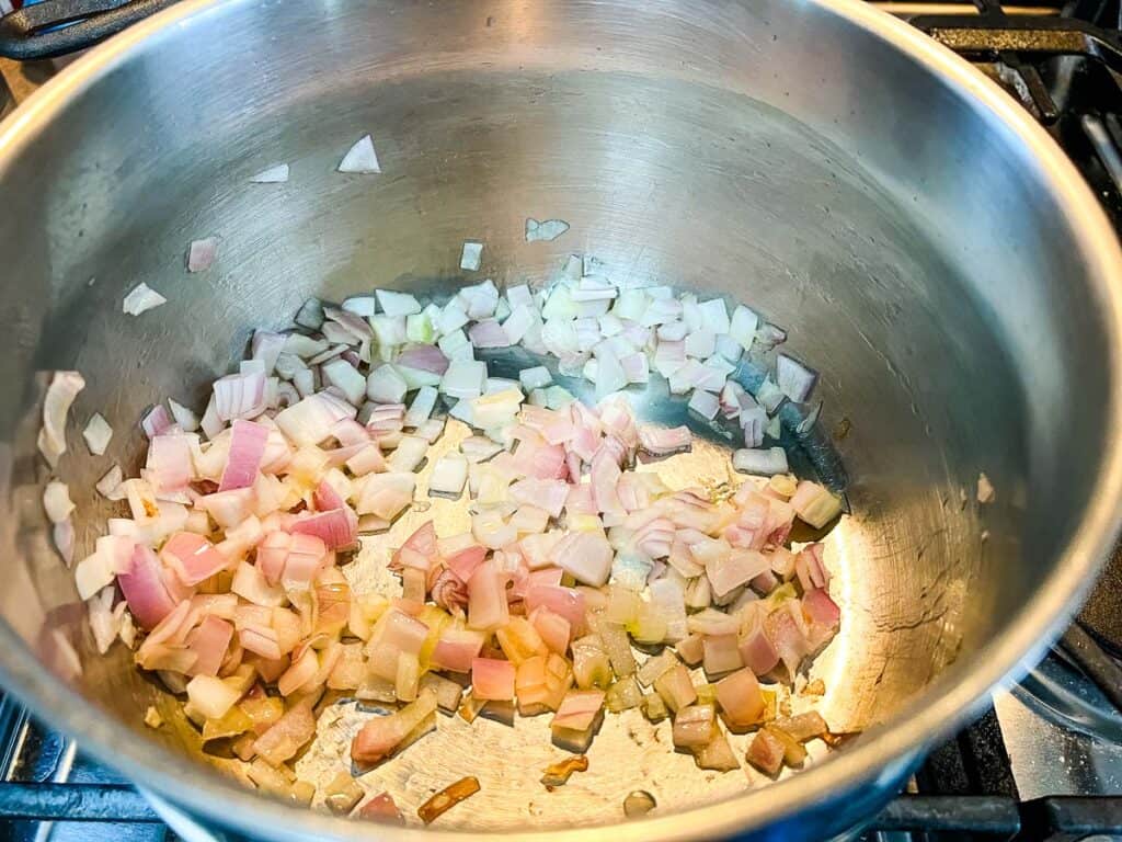 Sauteing the shallots in a soup pot.