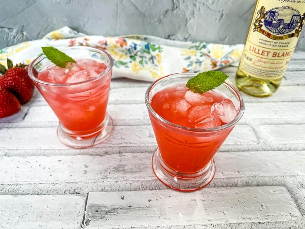Horizontal shot of 2 glasses of Strawberry-Lillet Crush cocktails.